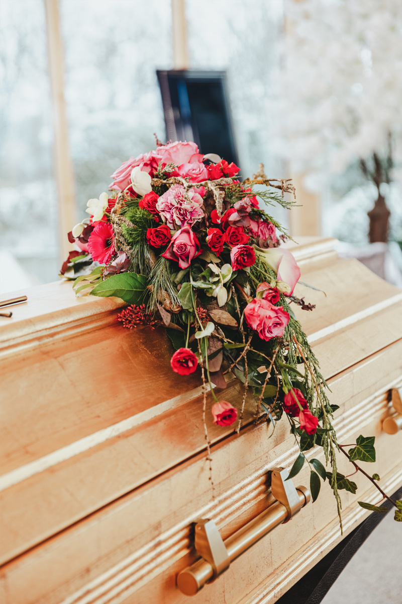 Sarg mit Blumenschmuck